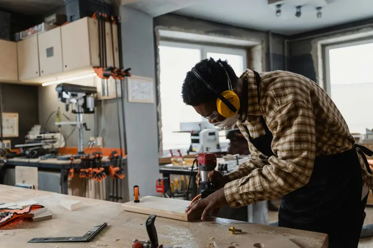 Artisan en train de travailler le bois dans son local